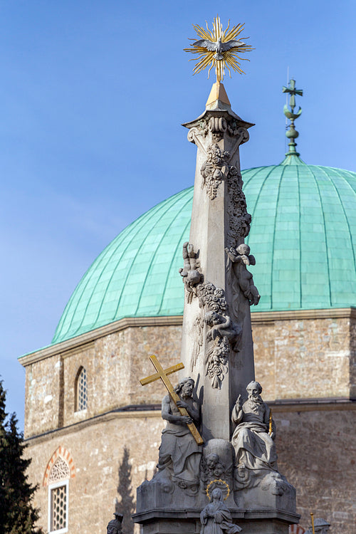 Holy Trinity statue with the mosque of pasha Qasim the Victoriou